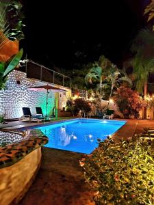 een zwembad in een achtertuin 's nachts bij Hotelito Swiss Oasis -Solo Adultos - Adults only in Puerto Escondido