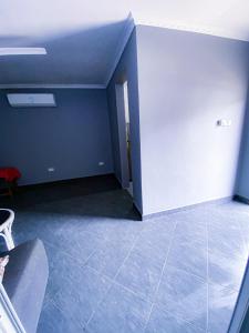 Zimmer mit blauer Wand und Fliesenboden in der Unterkunft Homeaway4m home in Daressalam