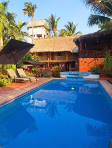 una piscina frente a una casa con complejo en HOTELITO SWISS OASIS, Playa Zicatela - Adults Only - Kitchen - Cocina, en Puerto Escondido