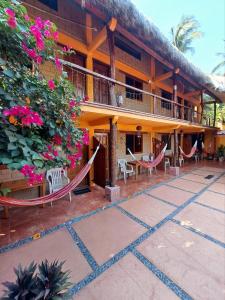a resort with hammocks outside of it at HOTELITO SWISS OASIS, Playa Zicatela - Adults Only - Kitchen - Cocina in Puerto Escondido