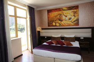 Schlafzimmer mit einem Bett mit Wandgemälde in der Unterkunft Smith Hotel Baku in Baku