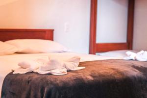 dwa ręczniki siedzą na krawędzi łóżka w obiekcie Hotel Tierra Roja By MH w mieście Barichara