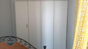 a white closet with white cabinets in a room at LoveAlghero stanze in attico vista mare in Alghero