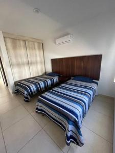 1 dormitorio con 2 camas y mantas azules y blancas en Tu casa en Mazatlán,, en La Florida