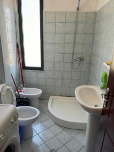 a bathroom with a toilet and a tub and a sink at Apartament M&L in Golem