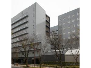 a tall gray building with trees in front of it at Osaka Academia - Vacation STAY 78661v in Osaka