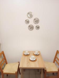 a table with two chairs and a clock on the wall at Ksenia in Neumünster
