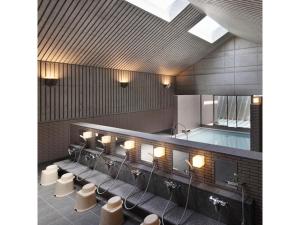 a lobby with a row of sinks and white stools at Osaka Academia - Vacation STAY 78649v in Osaka +17 photos