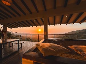 una camera con un letto con un tramonto sullo sfondo di Villa Canopy Minca a Minca