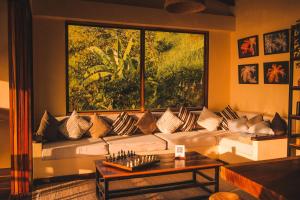 a living room with a couch with a large window at Villa Canopy Minca in Minca