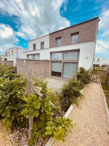 a white house with a wooden fence in front of it at Maison Coxyde in Koksijde
