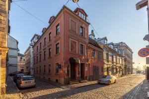 un edificio rojo al lado de una calle en Amber Private Rooms, en Riga