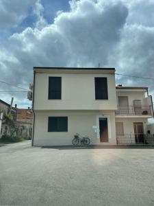una casa bianca con una bici parcheggiata di fronte di Dimora Anna a San Giacomo degli Schiavoni Altre 23 foto