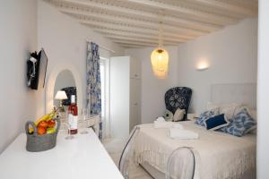 ein weißes Schlafzimmer mit einem Bett und einem Obstkorb in der Unterkunft Fino Amore in Megali Ammos