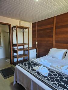 um quarto com uma cama e uma cabeceira em madeira em Pousada Villa Encantada Ilha do Mel na Ilha do Mel