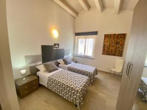 a bedroom with two beds and a table and a window at Appartamento in centro paese in Monterosi