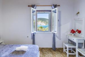 a bedroom with a window with a view of the ocean at Anesis Apartment 1 in Panormos Skopelos