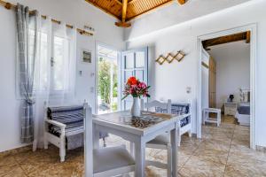 a white dining room with a table and chairs at Anesis Apartment 1 in Panormos Skopelos