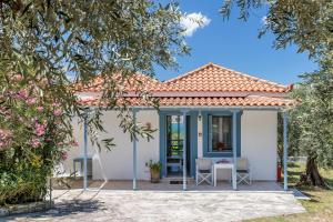 a small white house with a table and chairs at Anesis Apartment 1 in Panormos Skopelos +17 photos