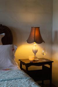 a lamp on a table next to a bed at Blue Fattoria Luxury Farm Accomodation in Fernside