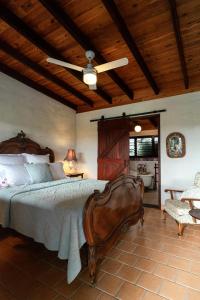 a bedroom with a large bed with a wooden ceiling at Blue Fattoria Luxury Farm Accomodation in Fernside