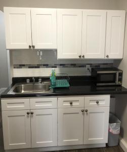 a kitchen with white cabinets and a sink at Private 2-bedroom apartment and New York City Manhattan only 15 mins away in Union City