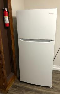 a white refrigerator in a room with a fire extinguisher at Private 2-bedroom apartment and New York City Manhattan only 15 mins away in Union City