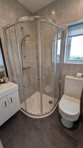 a bathroom with a shower and a toilet at Lane End Cottage Holmfirth - Panoramic Views, Modernised with offroad parking in Holmfirth +47 photos
