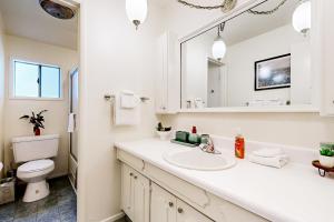 ein weißes Badezimmer mit Waschbecken und Spiegel in der Unterkunft Natures Reserve in Lake Arrowhead + 27 Fotos