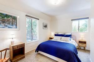 1 Schlafzimmer mit einem blauen Bett und 2 Fenstern in der Unterkunft Natures Reserve in Lake Arrowhead