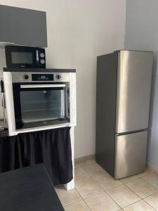 a kitchen with a microwave and a refrigerator at Chez Eric in Rémiré +3 photos