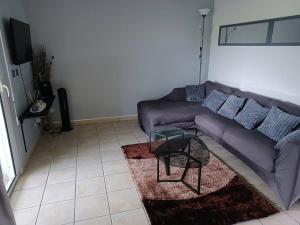 a living room with a purple couch and a table at Chez Eric in Rémiré