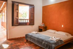 a bedroom with a bed and a window at Hotel Tierra Roja in Barichara +90 photos