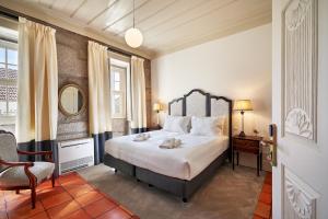 a bedroom with a large bed and a chair at Solar de Vilar Seco in Vilar Seco +101 photos