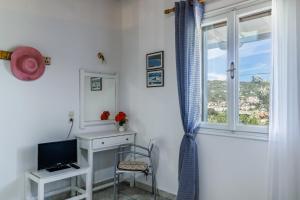 Pokój z biurkiem, telewizorem i oknem w obiekcie Anesis Apartment 2 Fireplace w mieście Skopelos