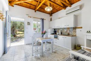 kuchnia z białymi szafkami i stołem w obiekcie Anesis Apartment 2 Fireplace w mieście Skopelos