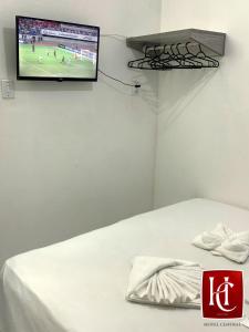Zimmer mit einem Bett und einem TV an der Wand in der Unterkunft Hotel Central Abaetetuba in Abaetetuba