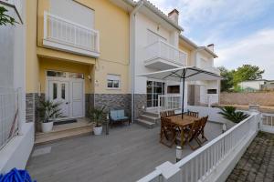 un patio con un tavolo e un ombrellone di Moradia Chicharro a Nazaré