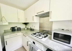 アシュフォードにあるAshford Retreat - Luxury Home with Double Parkingの白いキッチン(コンロ、電子レンジ付)