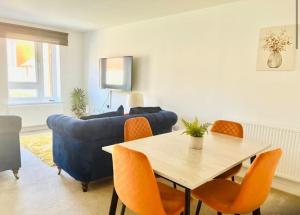 アシュフォードにあるAshford Retreat - Luxury Home with Double Parkingのテーブルと青いソファのあるリビングルーム