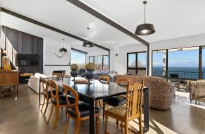 a dining room with a table and chairs and the ocean at Muritai House - Taupo in Taupo
