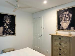 a bedroom with a painting of a man and a dresser at Whitfords Retreat - 2 Bedroom unit in Perth