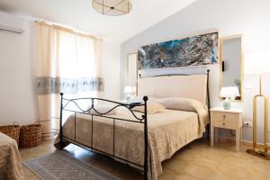 a bedroom with a bed and a painting on the wall at IL CASTELLO affittacamere in Posada