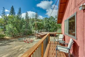 a deck with chairs and tables and trees at Pet-Friendly Escape with Game Room and Fire Pit! in North Fork