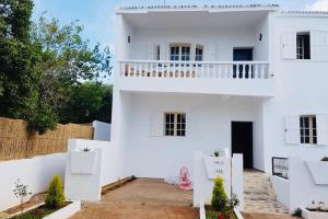 ein weißes Haus mit einem Balkon darauf in der Unterkunft Villa David front de mer in Bouznika + 10 Fotos