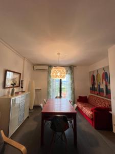 Maison Bellavista في Serra deʼ Conti: غرفة معيشة مع طاولة وأريكة حمراء