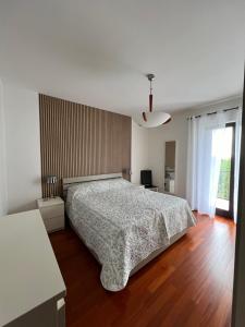 Maison Bellavista في Serra deʼ Conti: غرفة نوم بيضاء مع سرير وأرضية خشبية