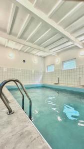 a large swimming pool with blue water in a building at Terimex in Pogorzelica