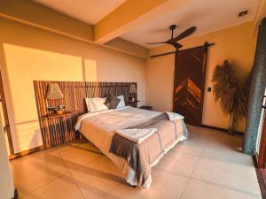 sypialnia z łóżkiem i wentylatorem sufitowym w obiekcie Villa Canopy Minca w mieście Minca