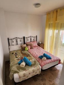 Un dormitorio con una cama grande con almohadas azules. en Green hills, en La Cala de Mijas 29 fotos más